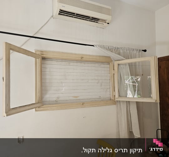 חלון פתוח עם תריסים ומזגן על הקיר